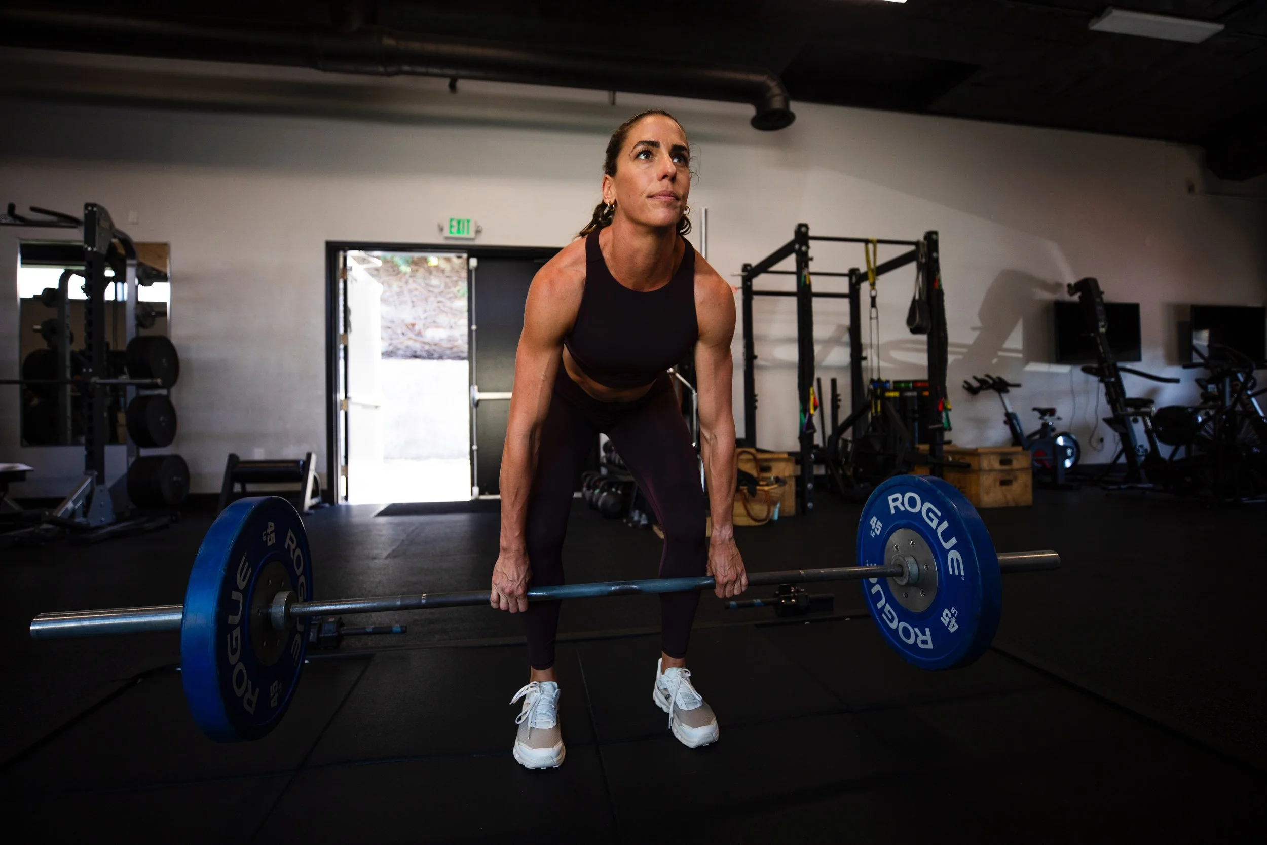 Gina Parlette strength training in a gym, founder of KŌA Wellness and peptide therapy coach.