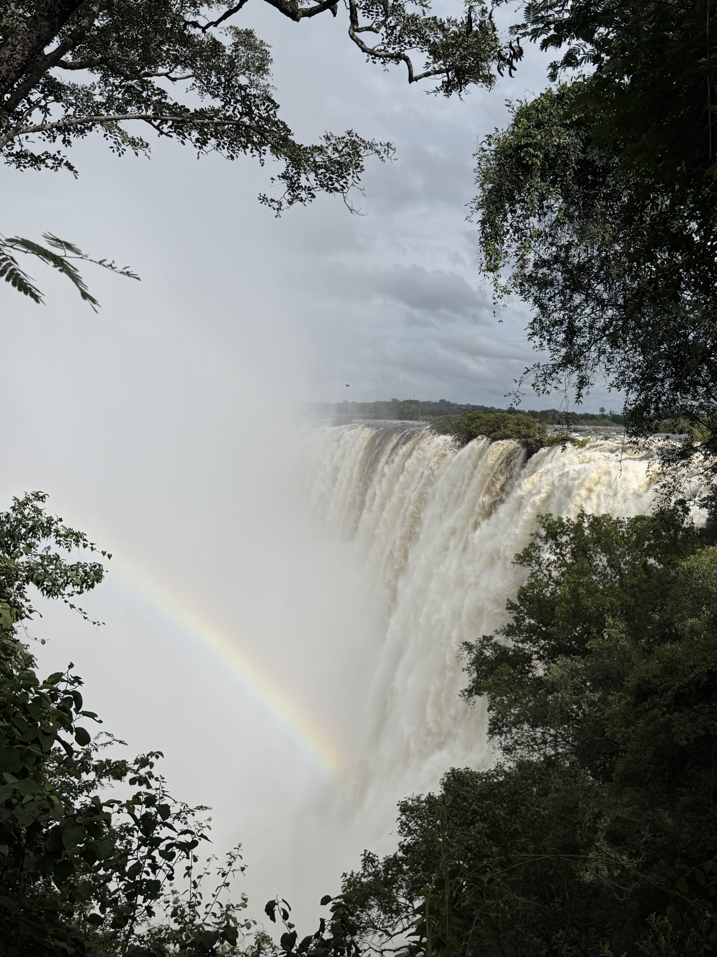 Large waterfall in Africa with rainbow in mist