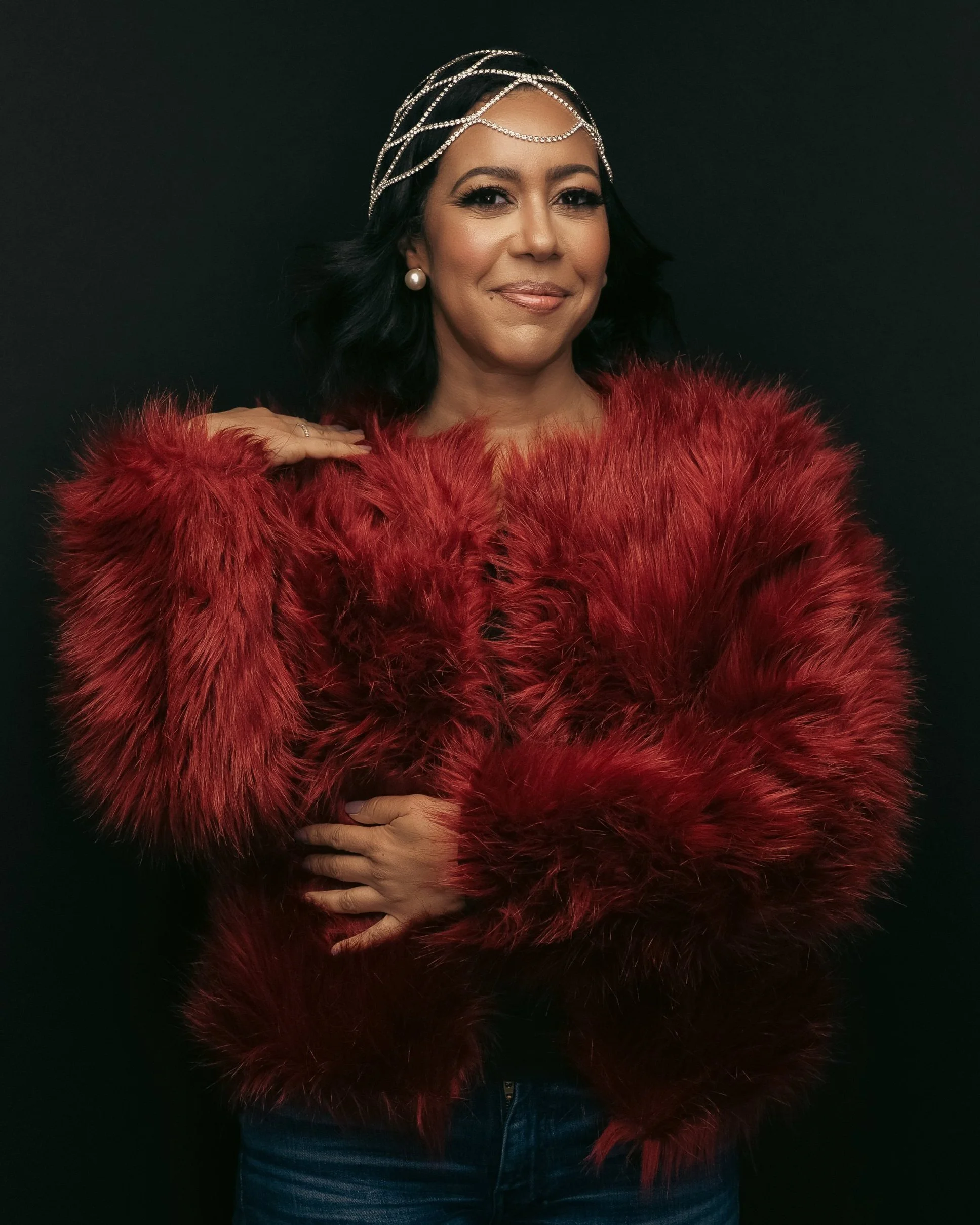 Serena is dressed in a lush red coat and posing in her power