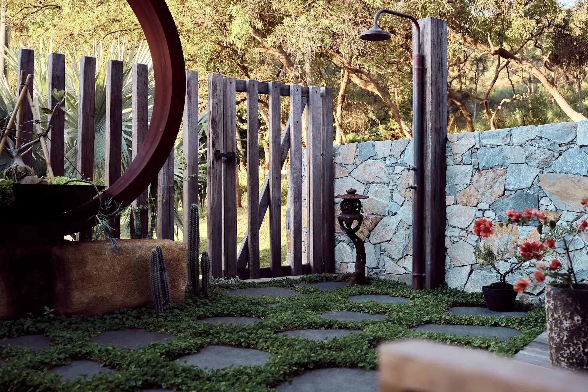 Corten steel ring on a boulder with cactus and crazy paving, Byron Bay