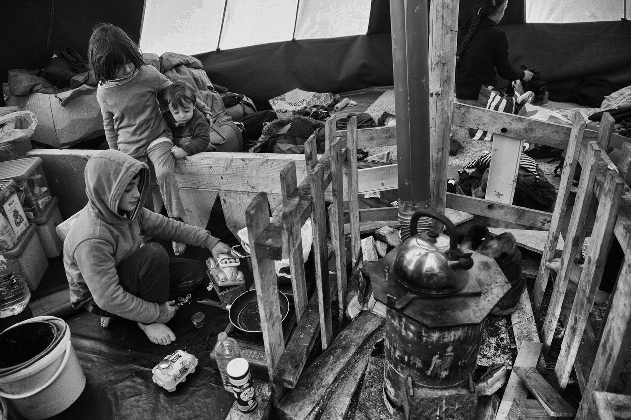  Kurdish children cooking eggs inside a tent at the makeshift camp of Grande-Synthe, Dunkirque, France, January 15, 2016. Photo Delmi Alvarez. 