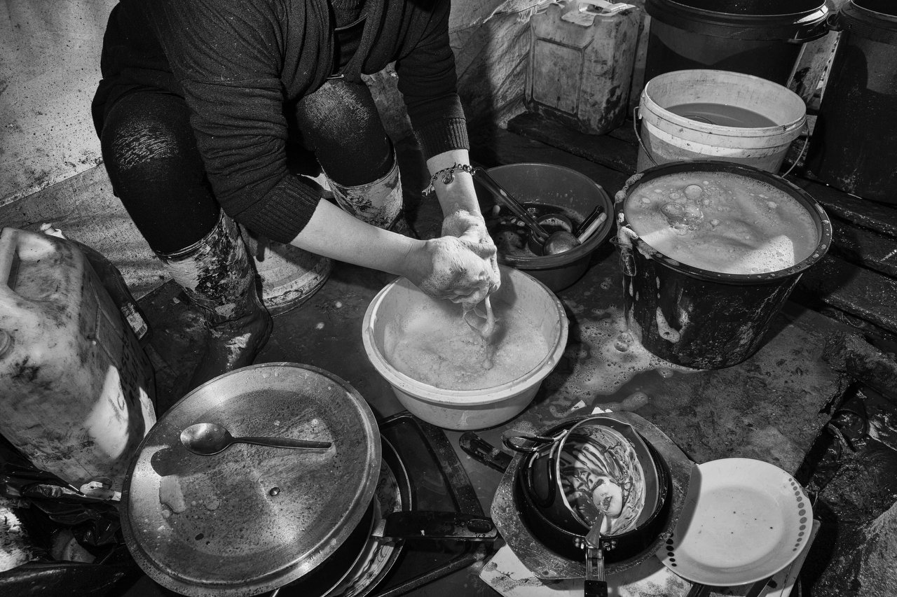  A Kurdish woman washes dishes at the refugee camp of Grande-Synthe, Dunkirki, France, January 8, 2016. Photo Delmi Alvarez. 