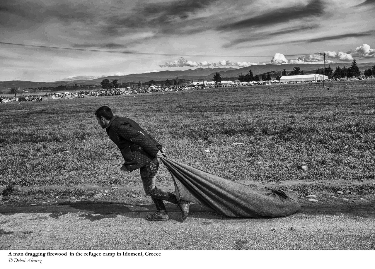  A man dragging wood for a bonfire at the refugee camp in Idomeni, Grece, March 8, 2016. Credit Photo © Delmi Alvarez. 