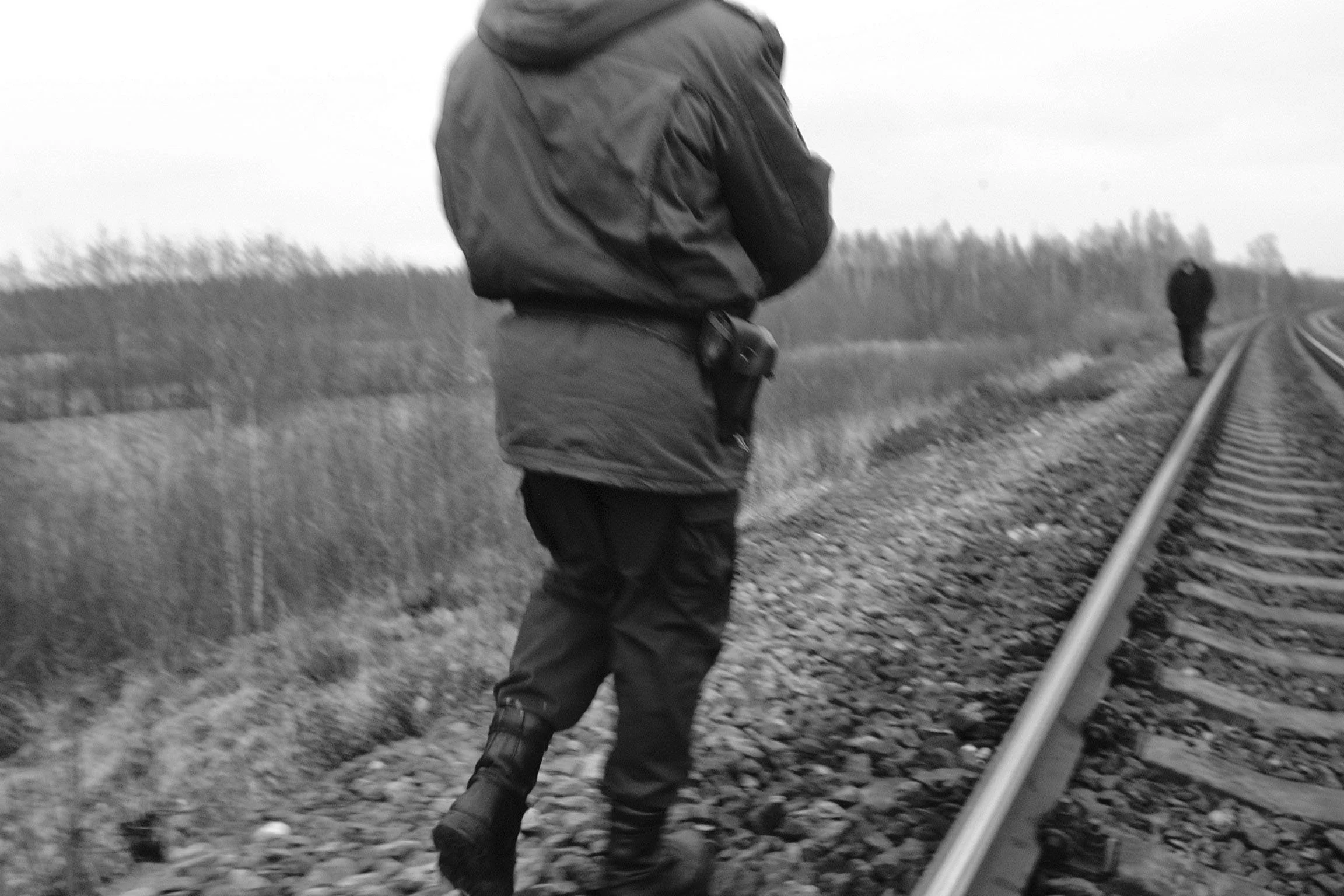  A border guard approaches a person who jumped off the train near the station of Punduri (Latvia), a spot where many migrants take advantage of the short distance between the Russian and Latvian borders to get off the train. 2003. 