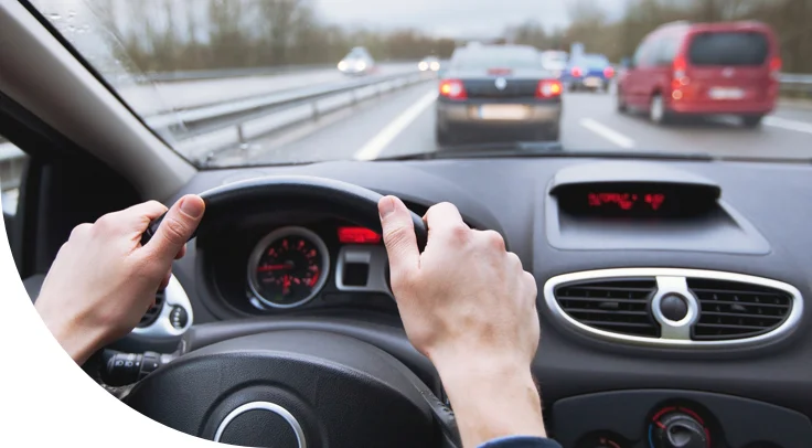 hands on steering wheel driving car on highway.jpg