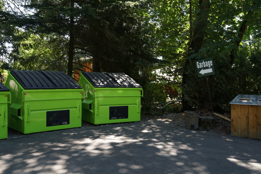 Garbage sign pointing to dumpsters