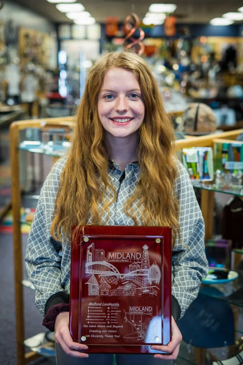Izzy Waldie poses with her artwork laser-engraved on a glass frame by Wellington Ltd in Midland