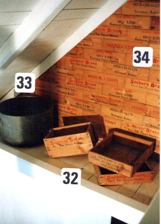 Fra Galleri driften på 80 tallet. Gamle originale sjablongmalte trekasser og kassebord brukt som veggdekorasjon på loftet. Kassene ble brukt til å pakke hermetikken for frakt og eksport.