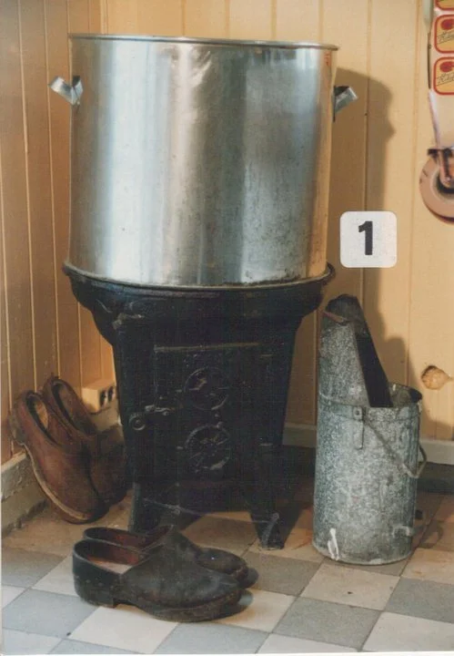 Vedfyringsovn og stor gryte som rekene ble forvellet i, før de ble pellet og lagt i boks.