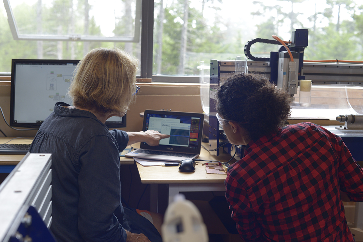 Two people discussing a design on a computer in the Haystack Fab Lab