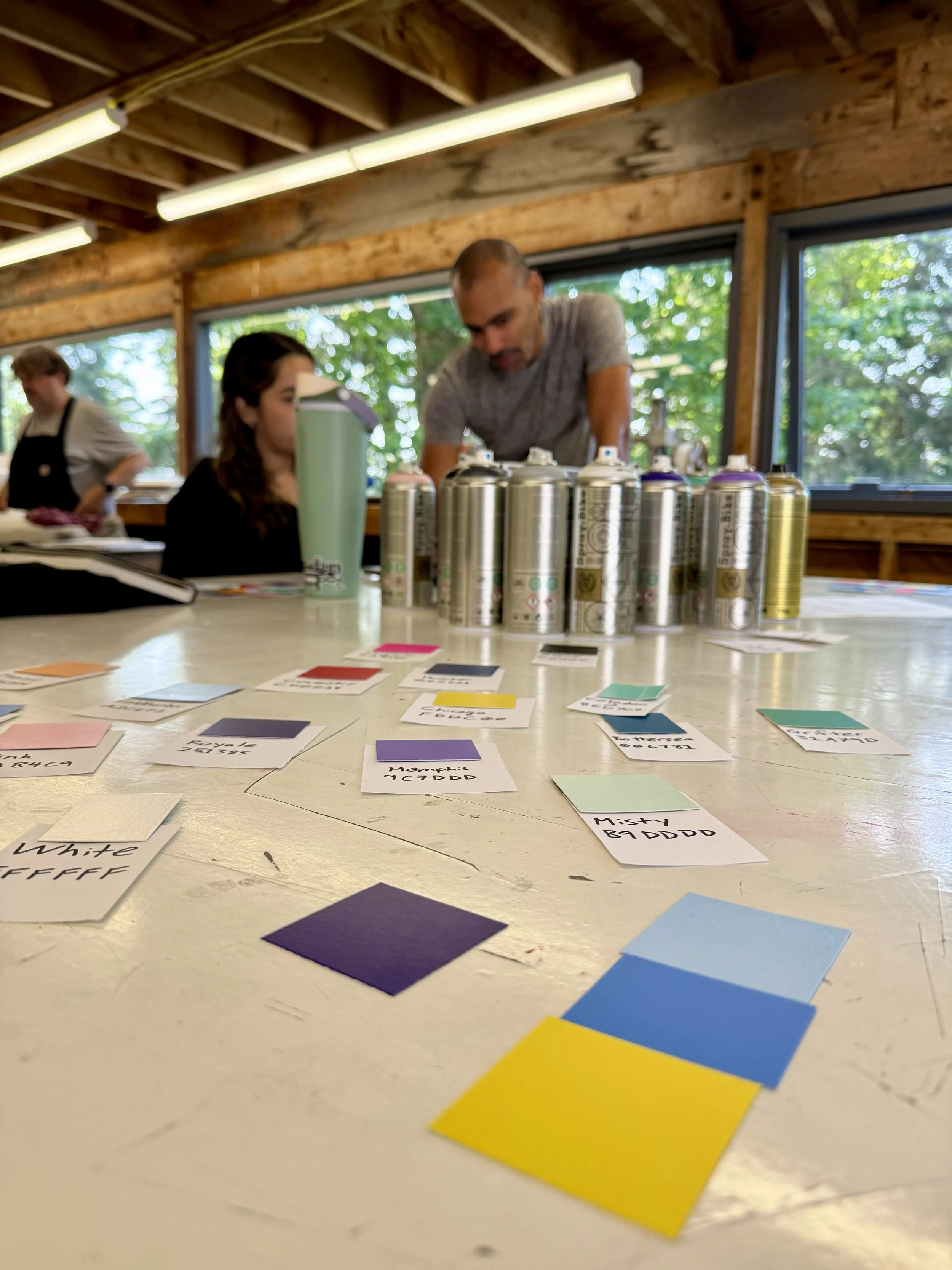 Graphics faculty Curtis Bullock (right) assists participant Carmen Ordoñez (left) during the 2025 Session workshop,  Breaking Down the Blank Page: Pop Art + Creative Systems . 