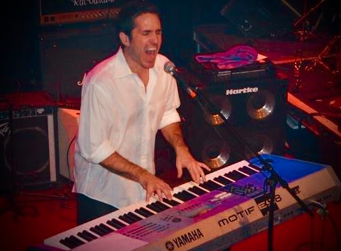Mac Quayle performing at a reunion show with the X-Raves at the Norva in 2008. Mac was such a familiar presence behind the keyboard for my generation. The reunion show evoked memories of hot summer nights spent playfully slam dancing around the packed floor of the Wave in Virginia Beach. Beer sloshing, arms flailing, everyone packed together and singing along to the X-Raves cover of Dancing With Myself. A snapshot in our collective minds that we all hold dear.