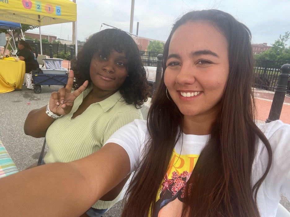  A photo/selfie of Destiny Treloar, right, and Te'Yah Wright (MEM student, class of 2023) volunteering at Holyoke's Farmers Market, aiding at the Healthy Incentive Program (HIP) informational booth.&nbsp; 