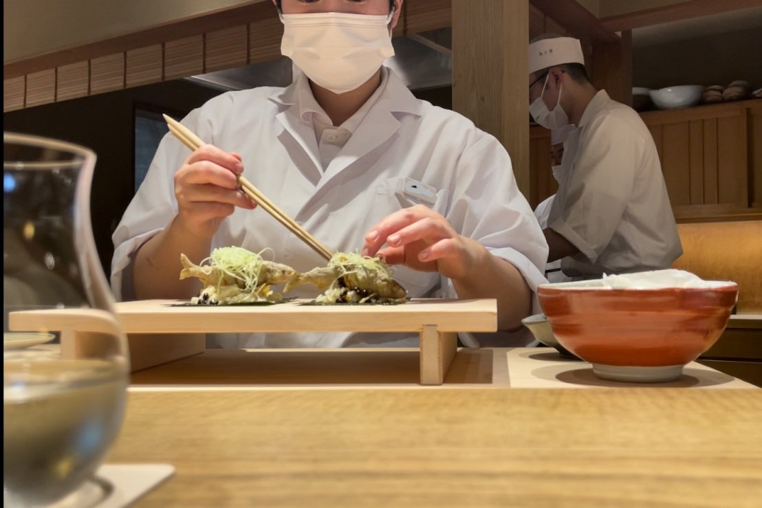 Dishes are finished in front of diners at the counter bar.