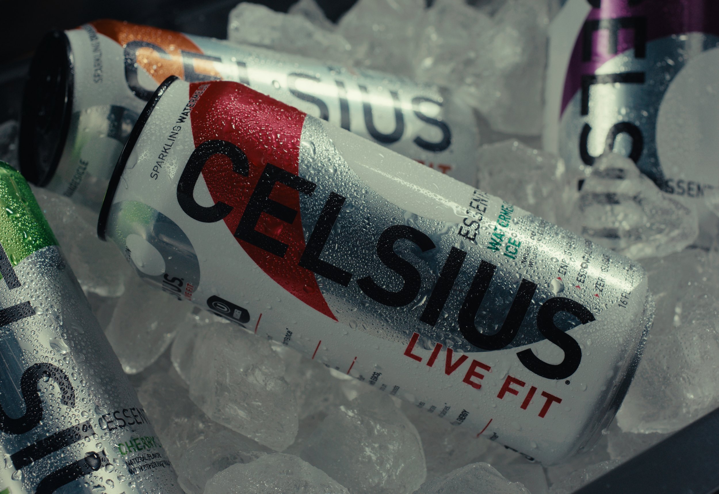 Celsius sparkling water cans covered in condensation, chilling in ice