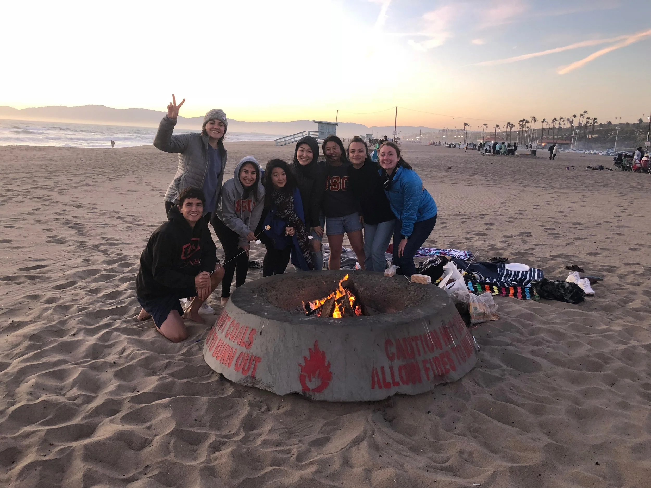 Trojan Shelter team enjoying smores at our beach bonding day.