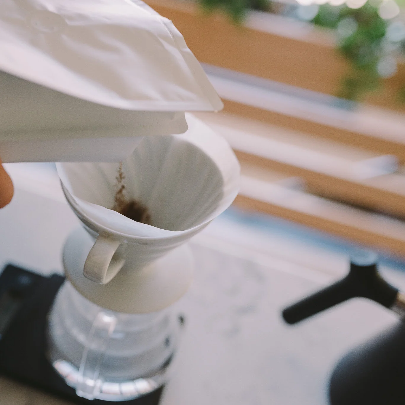 Adding coffee to V60 2 cup.