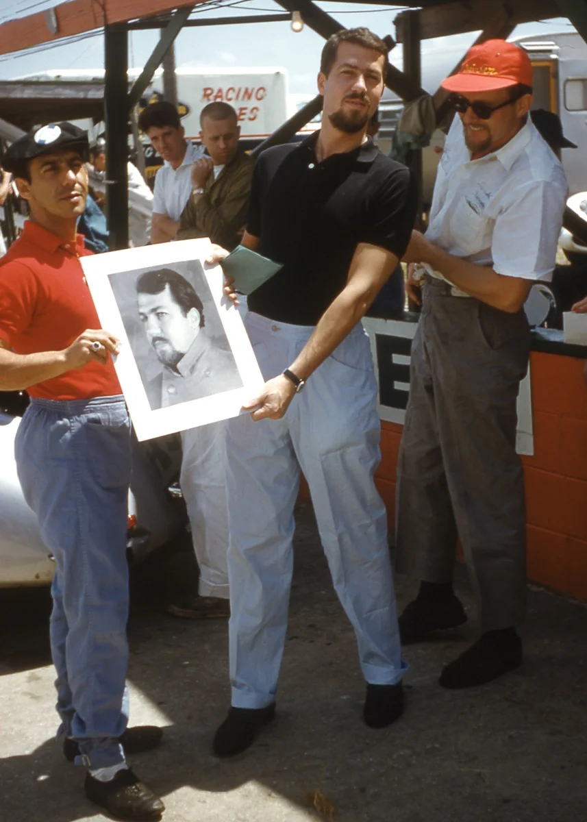 Swede Joachim Bonnier (black shirt) holds a drawing presented to him by Johnny Cuevas a wealthy Cuban whose family were Sugar barons.