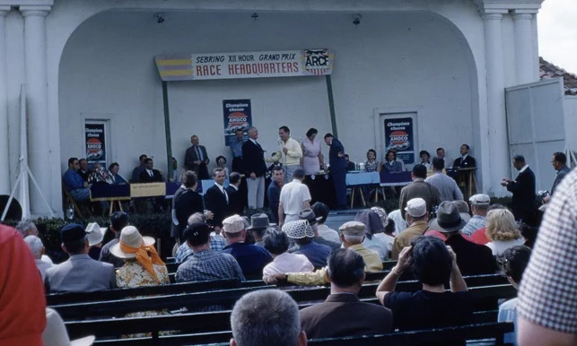 The awards ceremony on Sunday. Alec Ullman is being interviewed. Phil Hill in dark suit and white shirt and tie waits to come onstage.