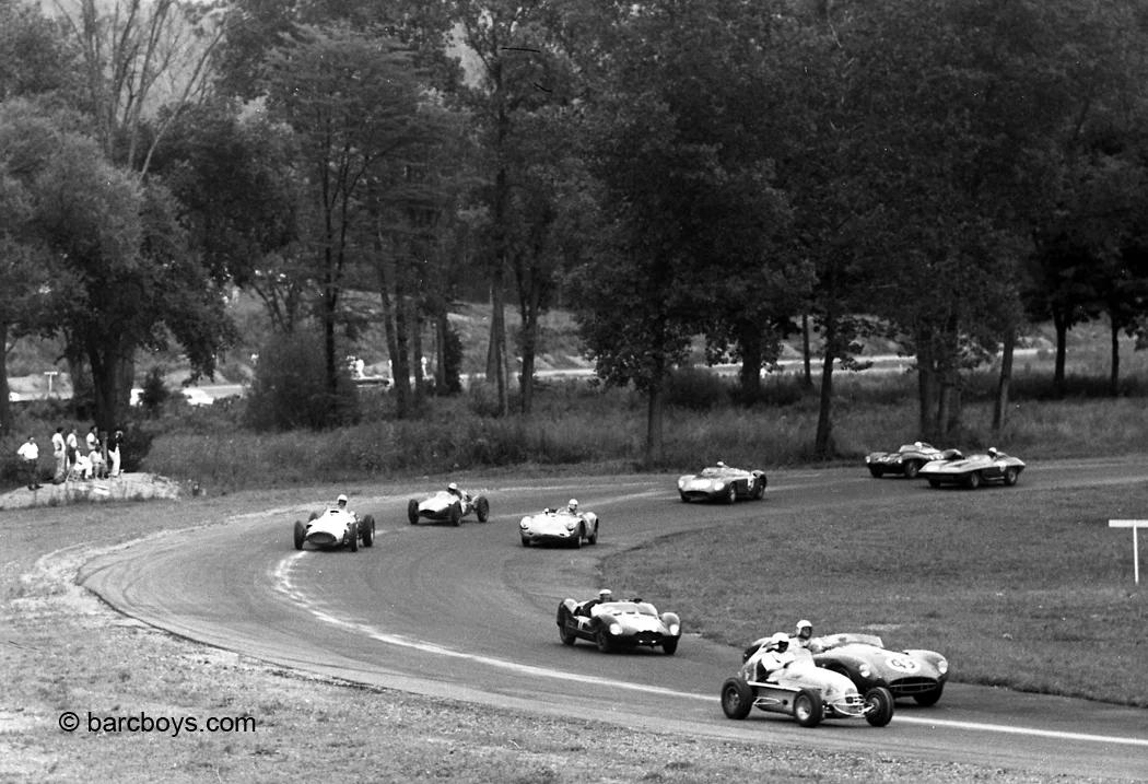 First lap and that pesky midget is not giving the huge Aston an inch.