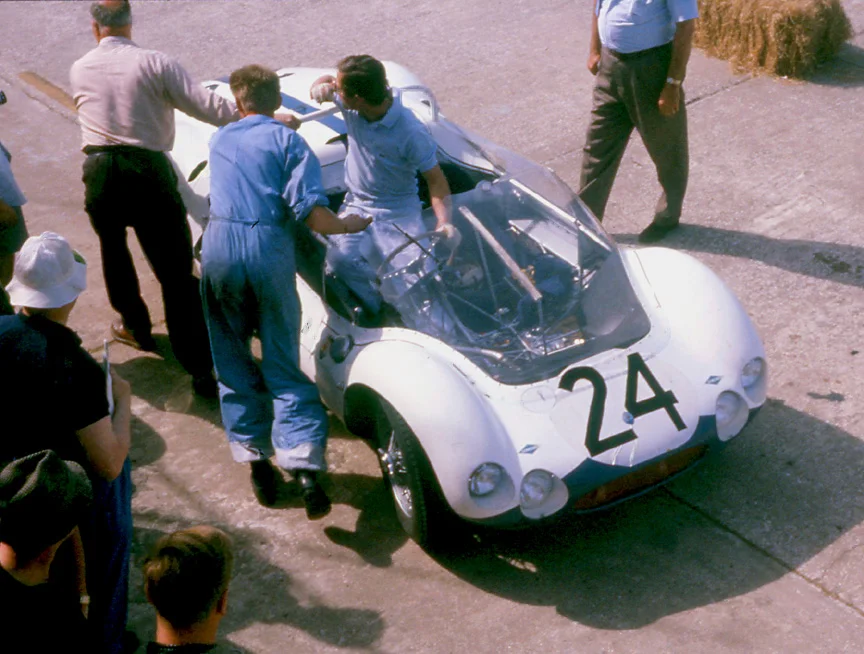 Masten Gregory, the Kansas Flash steers the Camoradi rear engined birdcage to its grid position. The car fairly long into the race but as was typical of the fragile birdcages, it was a DNF.