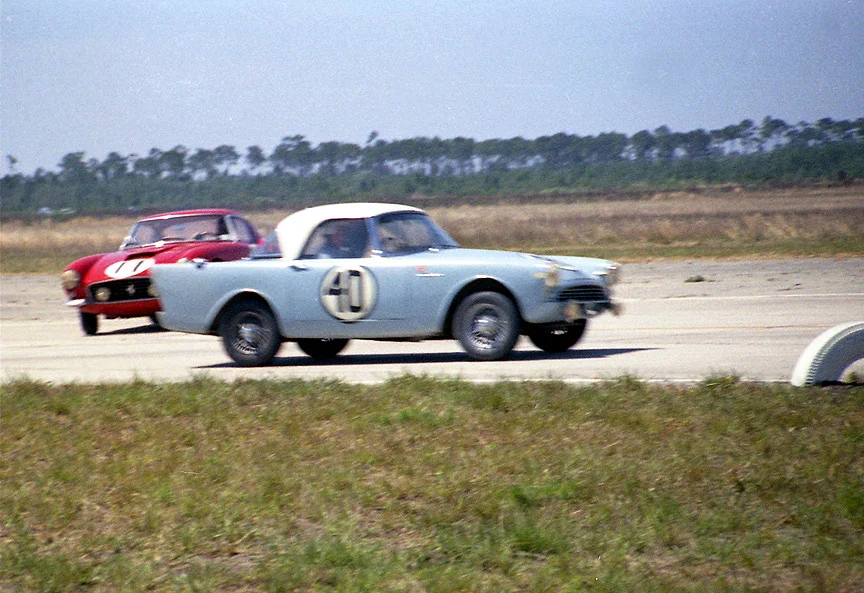 The Sunbeam Alpine #40 of Paddy Hopkirk passes the spinning #11 Serenissima Ferrari.