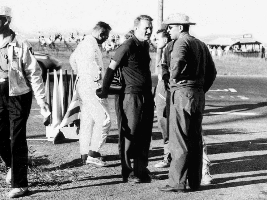 John Bishop (short sleeves) has a talk with Walt Hansgen (hat) at the start finish line. These men were giants in the SCCA and road racing.