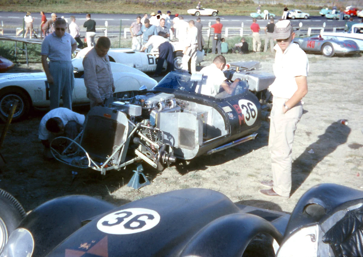 John Kelley captures work on the Kelso-Chev Lister with Cunningham’s crew working on #62 and the small bore production race forming on the grid.