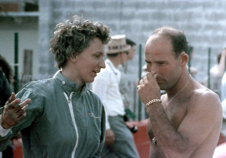 DENISE MC CLUGGAGE: In this photo you get two drivers. Denise talks something over with Stirling Moss. A wonderful history in the NY Times at https://www.nytimes.com/2015/05/10/sports/autoracing/denise-mccluggage-auto-racing-pacesetter-dies-at-88.html