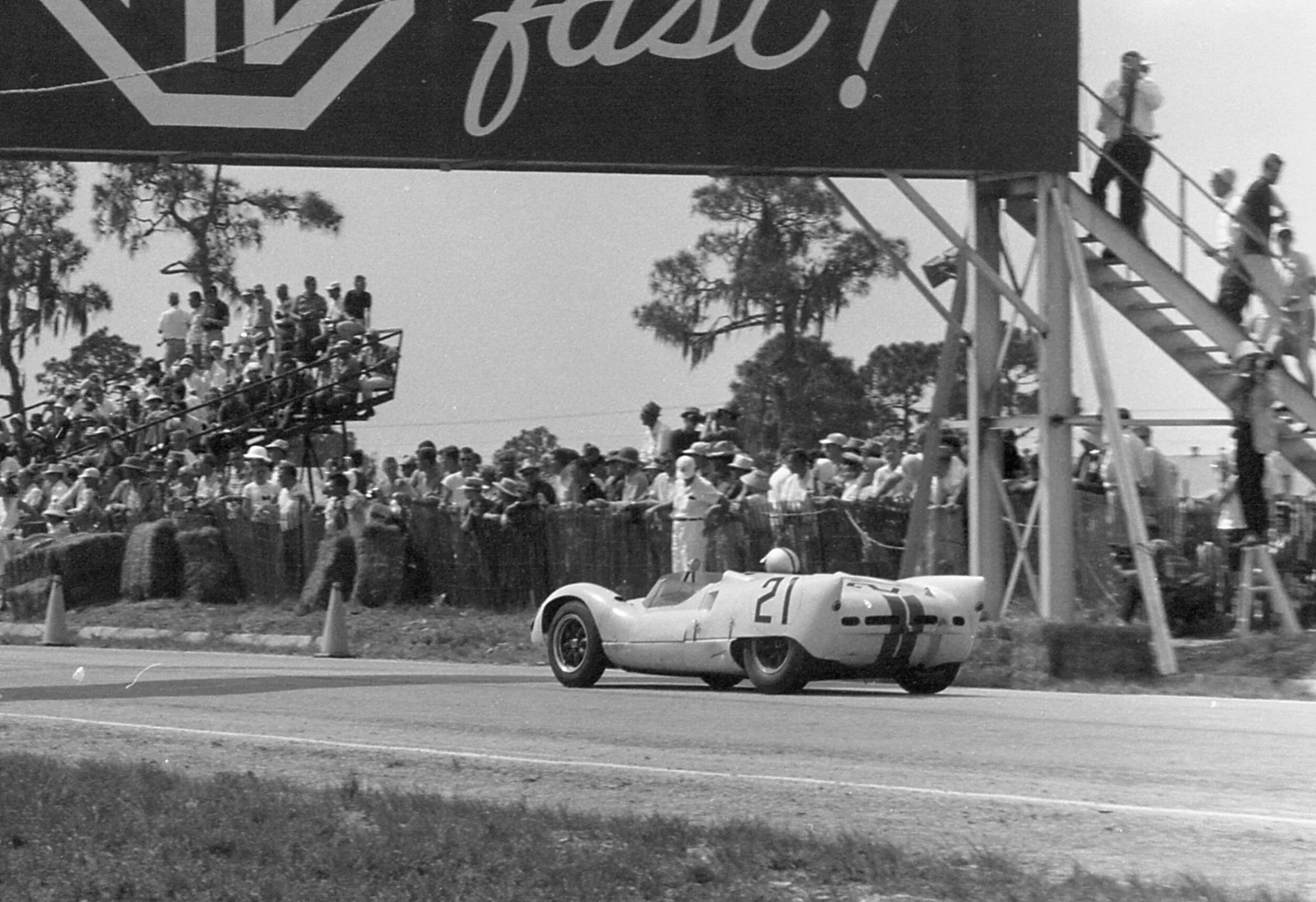 Roger Penske guides the Cooper Maserati T-61 under the MG Safety Fast bridge.