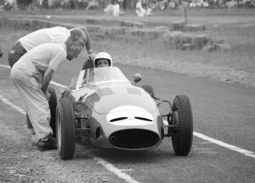 Denise McCluggage in the OSCA F junior talks things over at the beginning of the old pits.