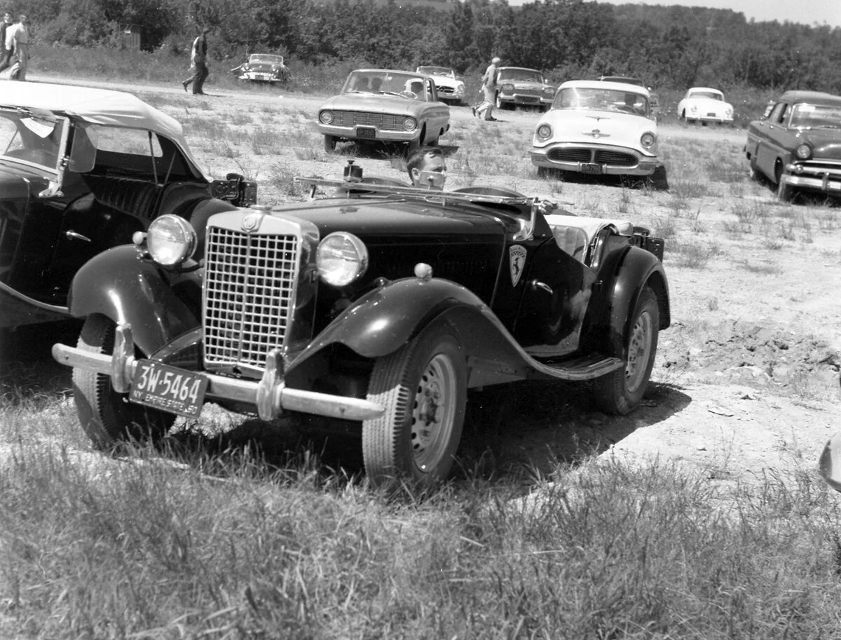The jet black MG-TD of Dave Nicholas. The car was bought with a bad engine from Karl Stickley and DN and his Dad rebuilt it in their driveway. The car had Derrington leather bucket seats and a custom aluminum grille.