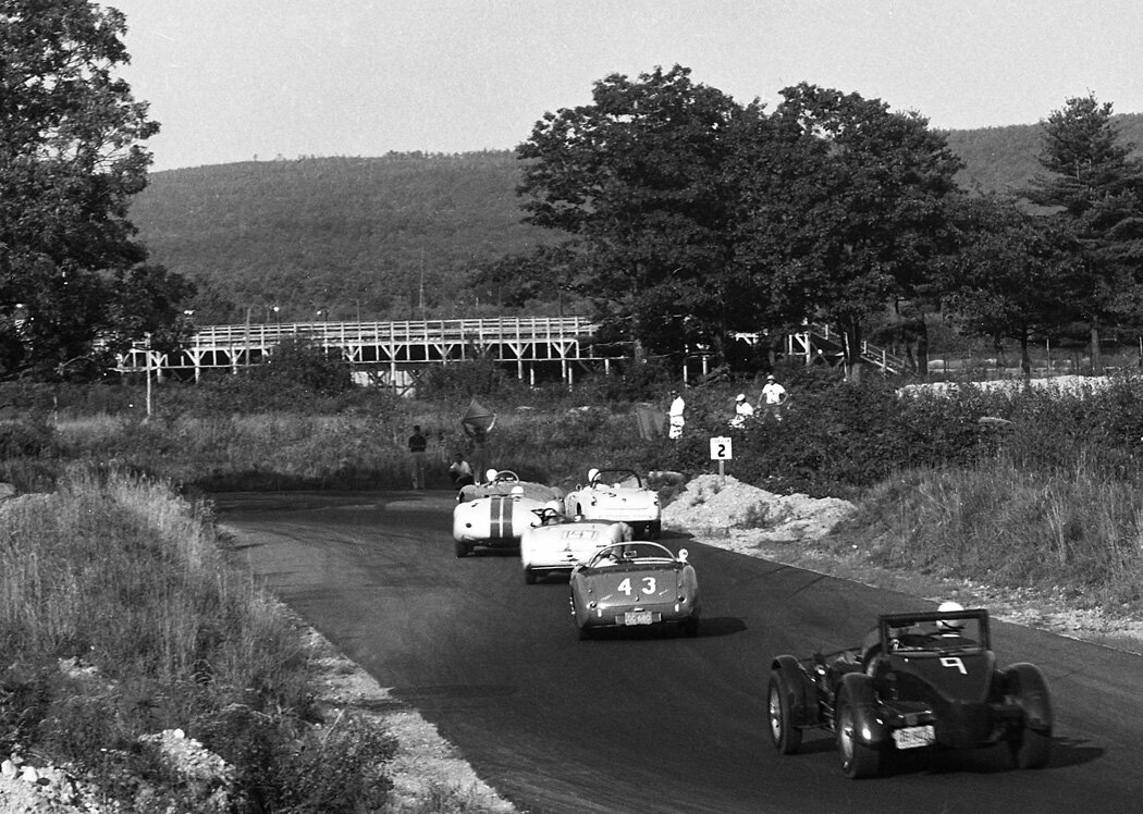 A great period photo during practice. BARC driver Bob Poupard’s MGA is followed by Chuck Stoddard’s #3 Alfa, The Lister Jag #60 of Walt Hansgen, Ken Fagan’s #47 Alfa then #43 Austin Healey of Charlie Hayes and the #9 Meyer Special of John Meyer. The grandstands in back are for the 1/2 mile oval track.