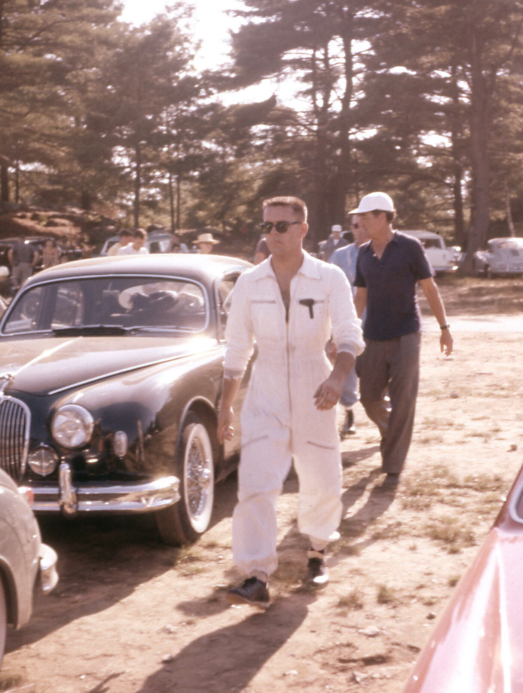 In this Phil Forno shot, Phil has driven Briggs Cunningham (black shirt) in the Jag sedan and is hustling off to get the cars ready to race.