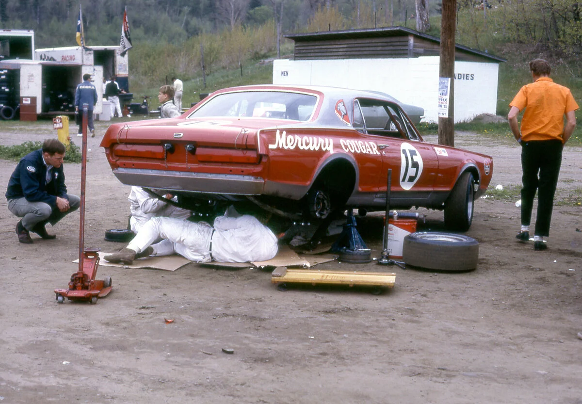 The old, dirt Lime Rock paddock we visited so often. The crew is under Revson’s Cougar. Note what was a “modern” block restroom in the background.