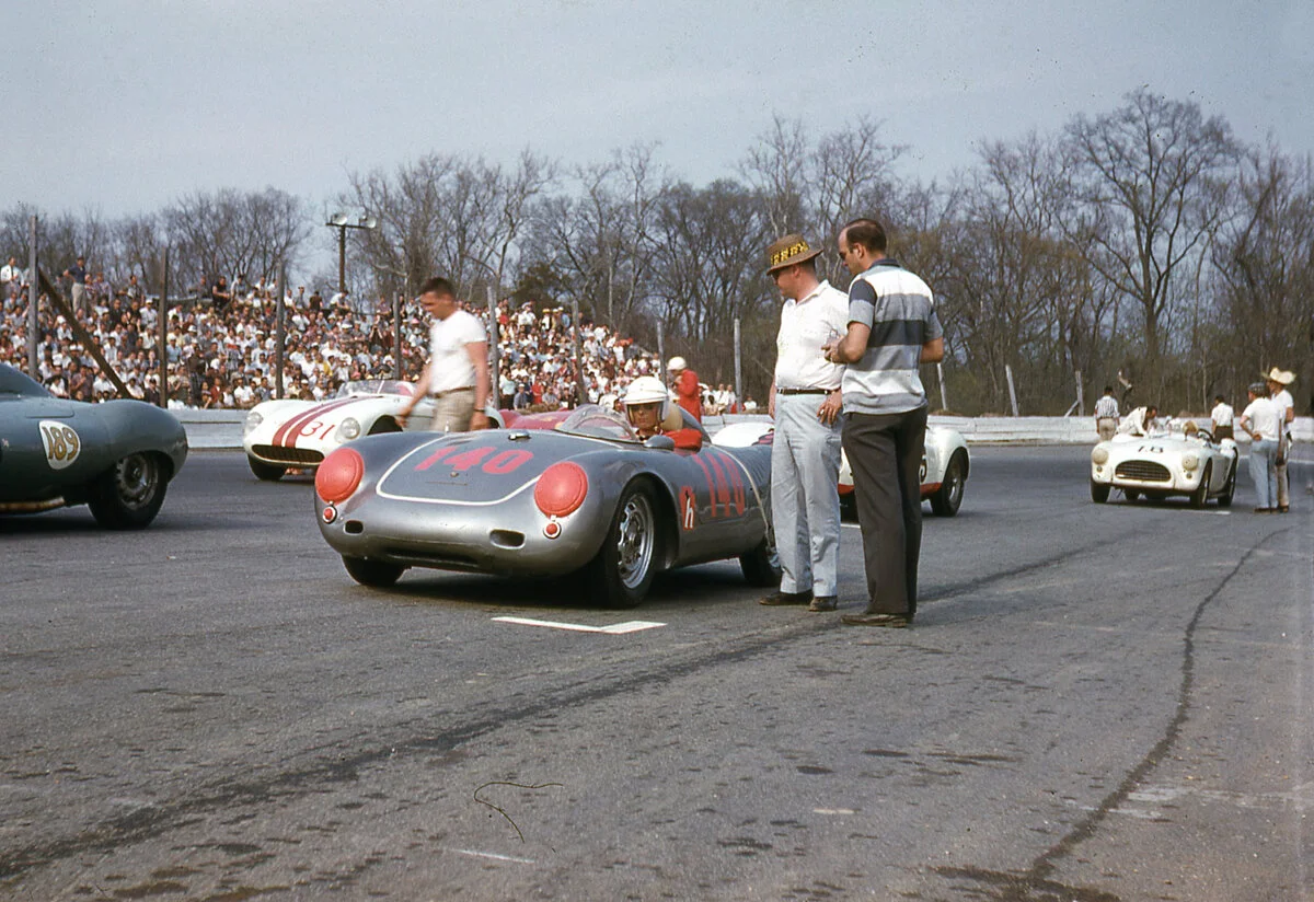 1958: Holbert wore his sunglasses and usually raced behind a face shield. Charlie Kolb’s Ferrari #31 sits behind.