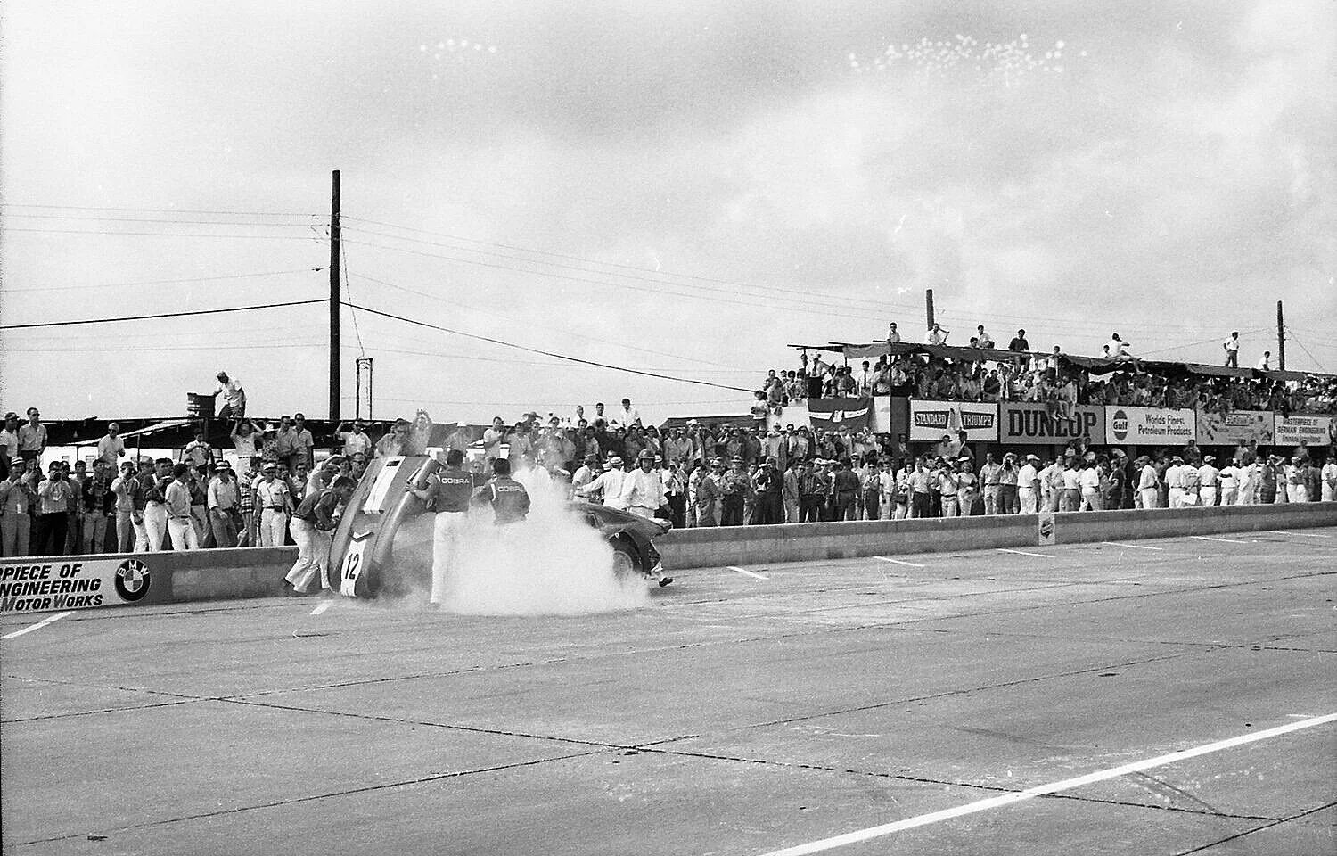 The crew has put out the fire and opened the hood. Fireworks and balloons mark the start of the race. Leslie comes around the back of the car ready to get in and go. #16 has finally started its race.