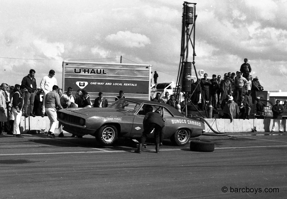  A Penske Camaro is in for service.  The RF wheel is off as crew members scamper to see what is wrong. 