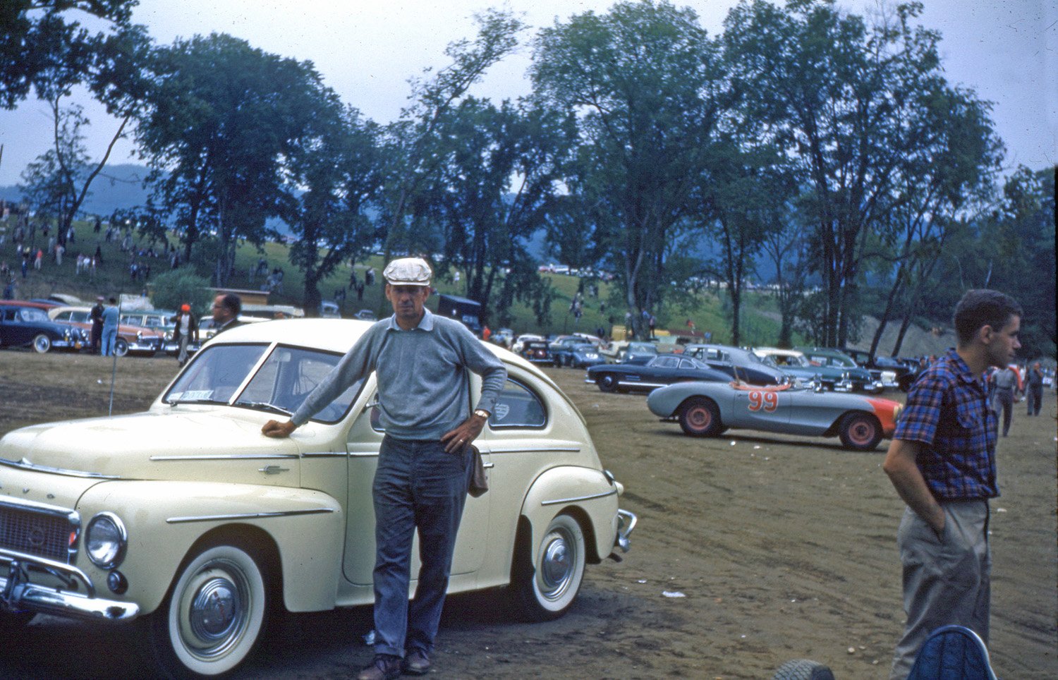  Another Bob Kahmer photo.  This is what now is Paddock A and completely level and paved.  The trees are gone but the spectator hill is there and improved.  Note the cars parked including Roy Tuerke’s 2nd place Corvette and a 300SL 