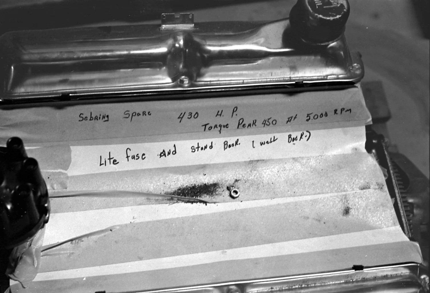  1965:  What’s the sense of working so hard if you can’t have a little fun?  The Ford crew needed to identify this spare motor and did so with style. 