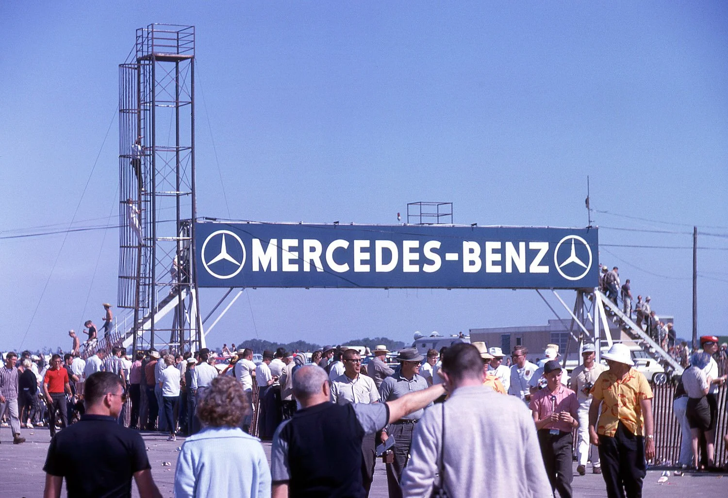  1962:  How to get from the paddock to the spectator area?  The best was always the Mercedes sponsored bridge.  Most anyone with a camera stalled on the steps up and down to snap a few photos.  A couple more adventurous souls are climbing the TV towe