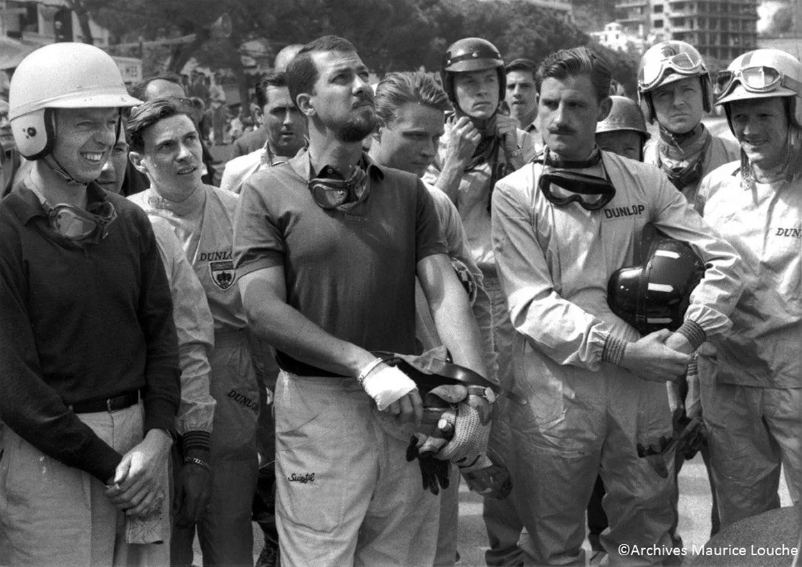  Monaco 1961.  L to R Tony Brooks, Jim Clark, Jack Brabham, Joe Bonnier, Dan Gurney, Graham Hill, Wolf von Trips,  Bruce McLaren. We think it is Richie Ginther’s helmet behind Graham’s shoulder. 