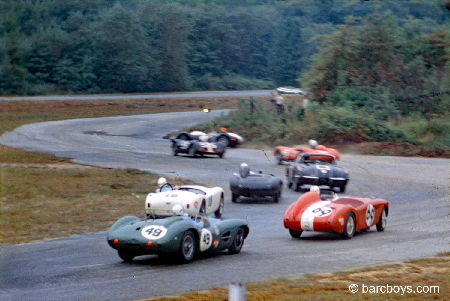  Constantine brakes hard to avoid a pack of cars as Jim Rathman goes off the road leaving the oval.  Roscoe Searles AC with a Jag engine is going left, Roger Ward is inside the Corvette of John Herrera.  Markelson’s Ferrari and Saidel’s Jomar go left