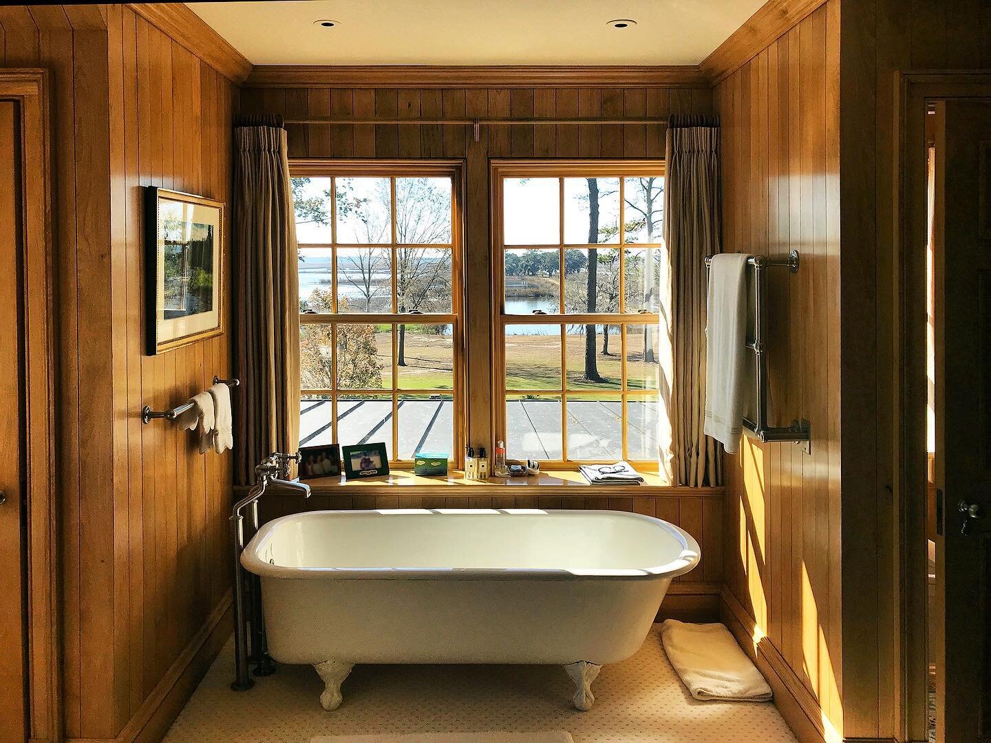 Beautiful natural light warmly floods this bathroom, paneled and trimmed in custom milled Hickory made in our Cabinetry and Millwork Workshop, with a six foot antique cast iron tub perfect placed to take in the incredible scenery. 
.
.
.
#beautifulba
