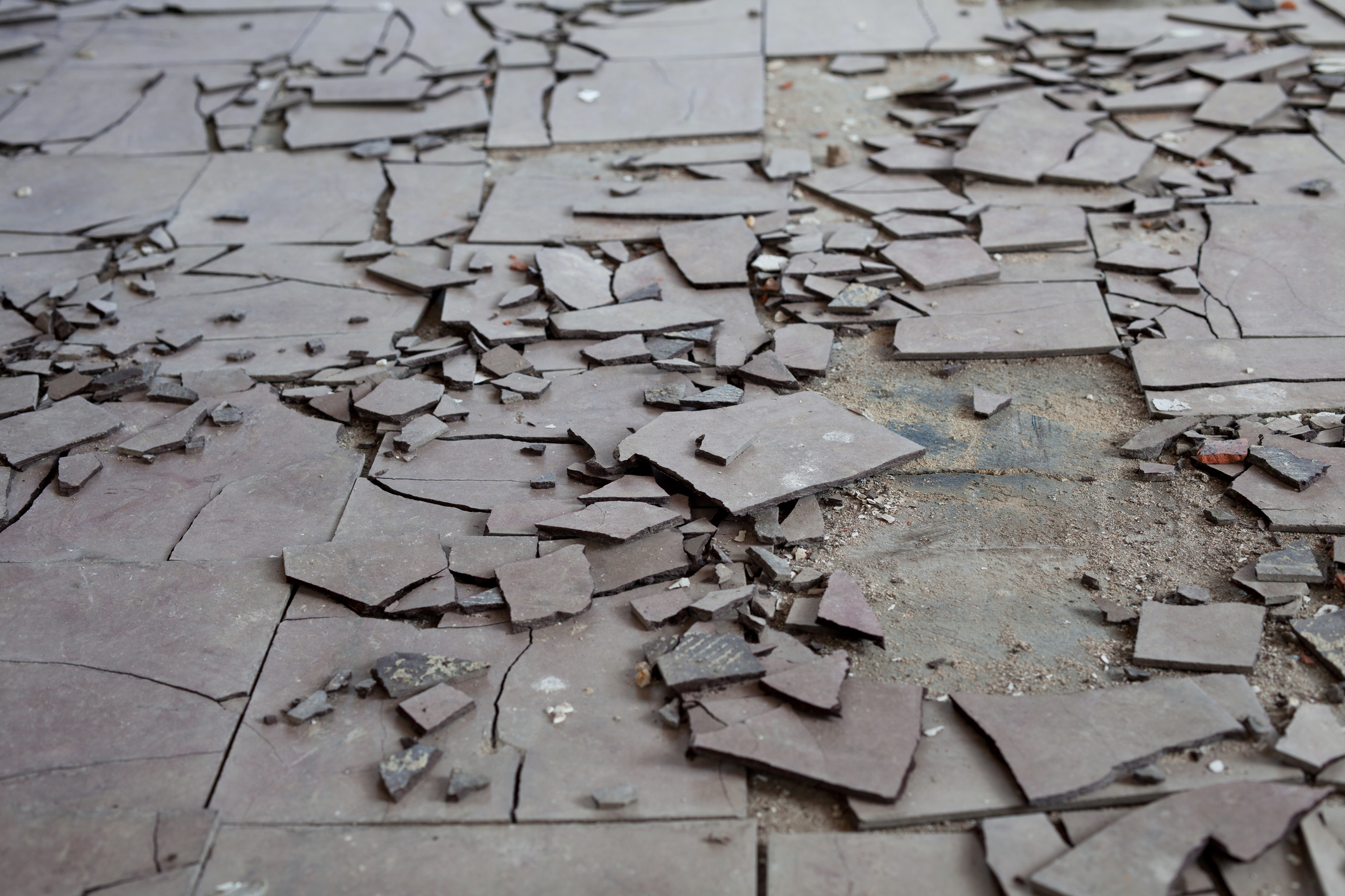 Разбитые полы. Разбитая плитка. Поломанная плитка. Трещины в бетоне. Треснула плитка на полу.