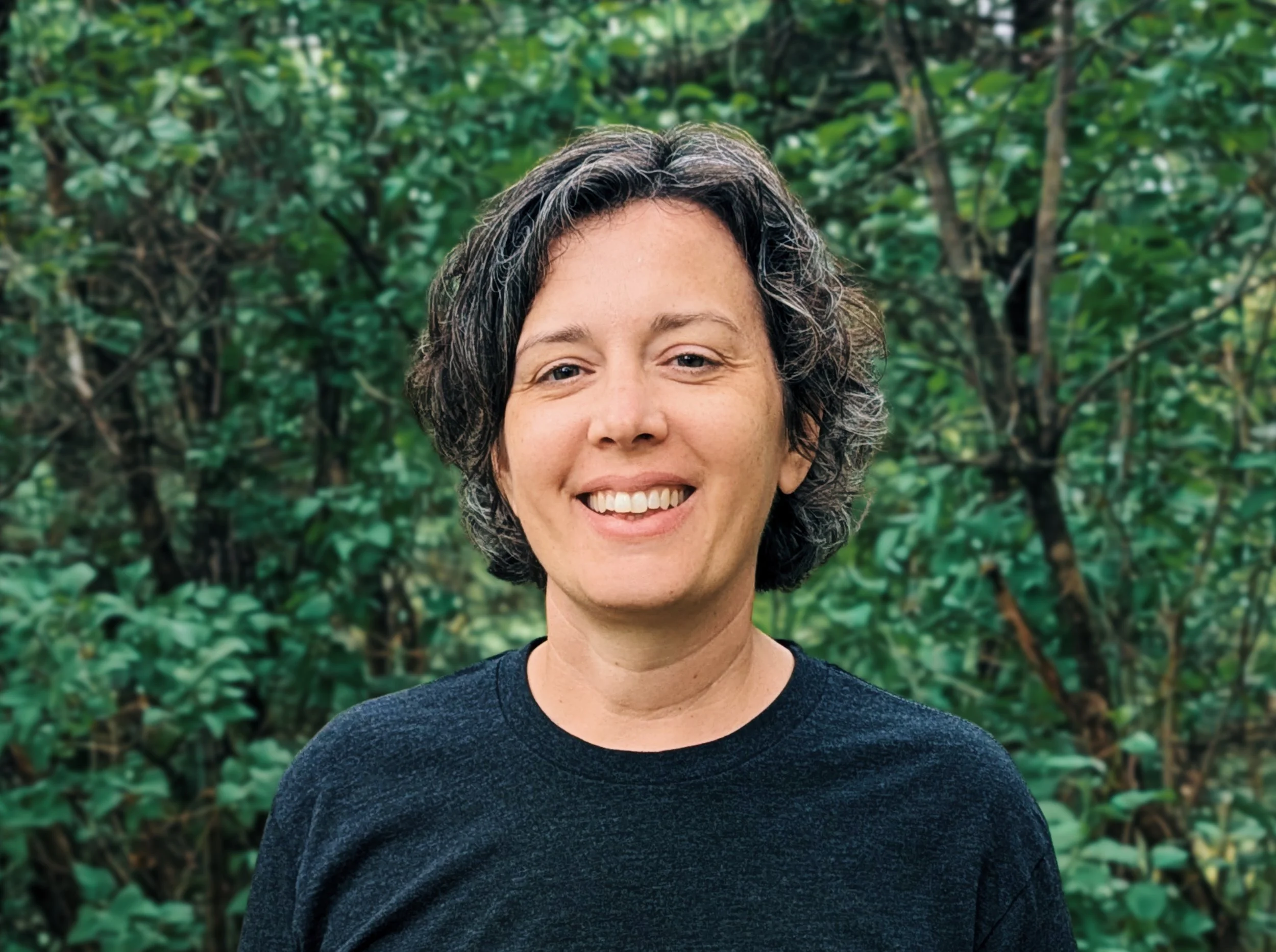 Illustration of a woman with medium-length brown hair wearing a gray shirt against a dark green background.