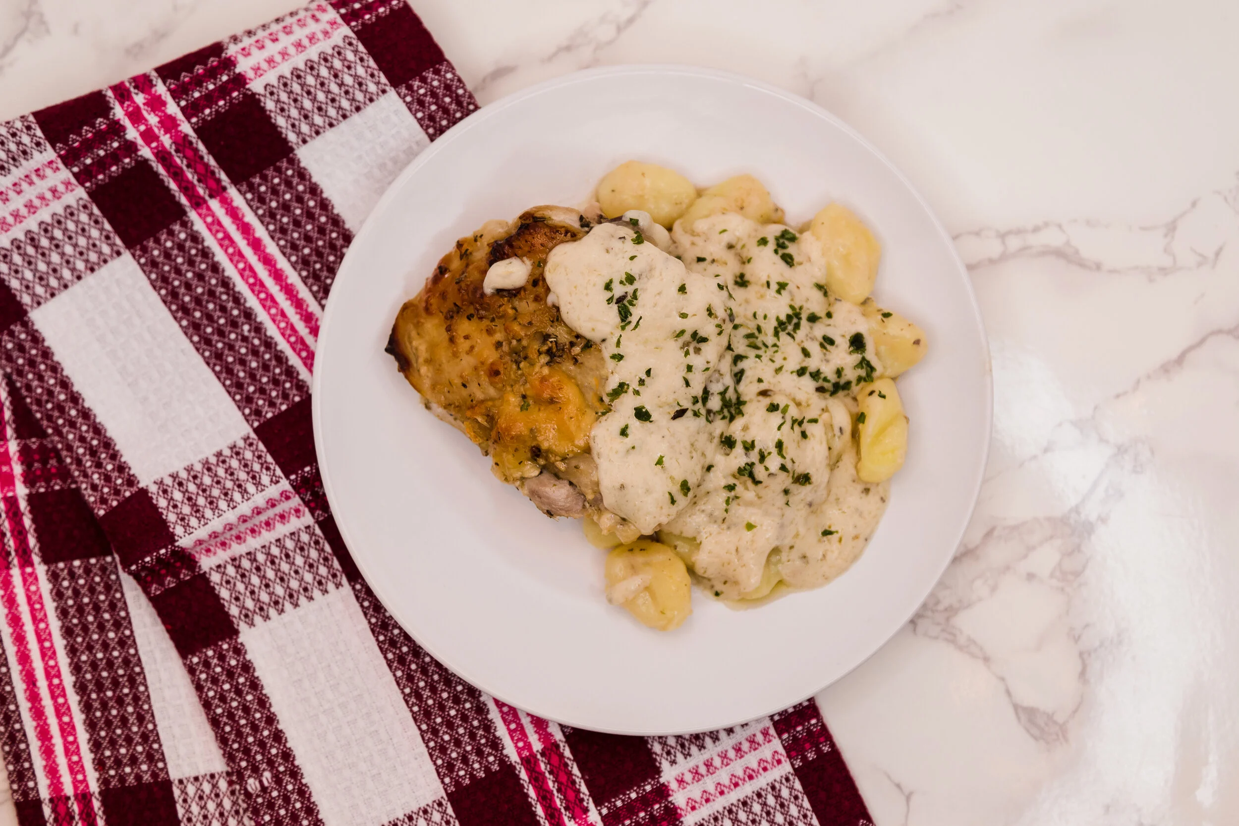 Italian Baked Chicken Thighs Over a Bed of Gnochhi with Cream Sauce
