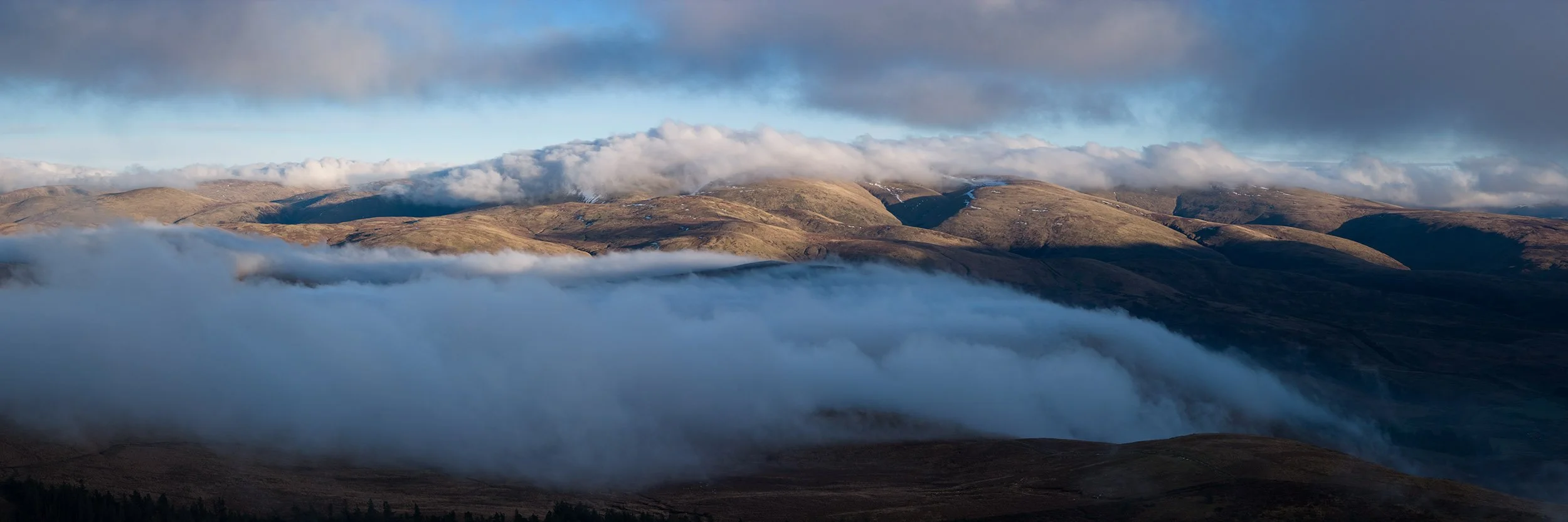 Mist flowing from Annandale head into Annandale with Hart Fell behind.