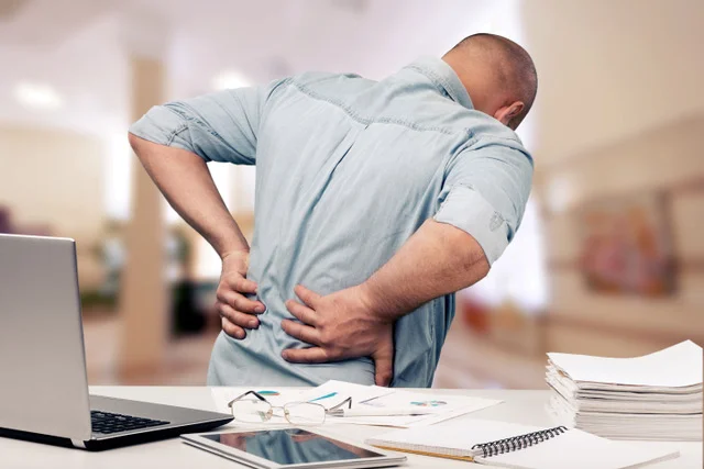 Man holding his lower back in pain.
