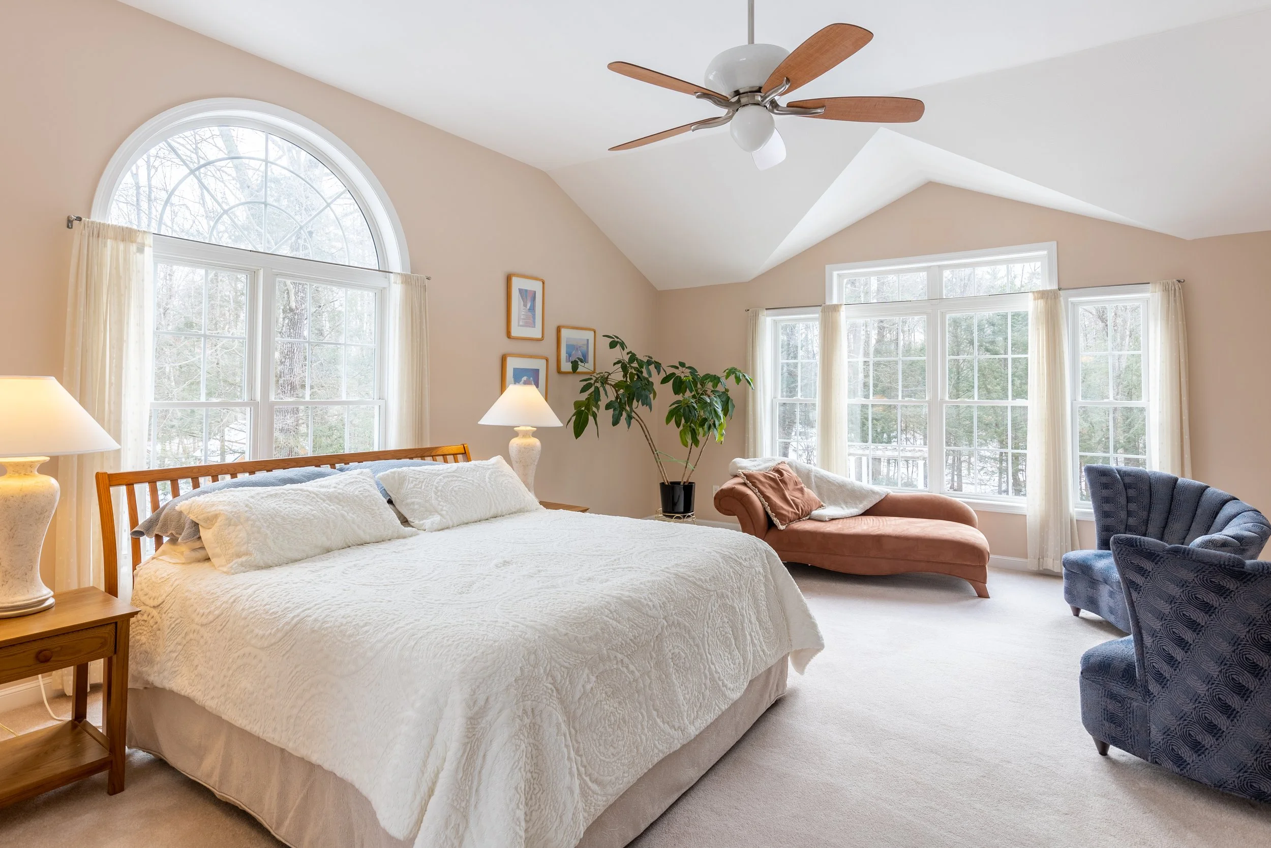 Neutral-toned bedroom with soft lighting and layered bedding creating a calm interior atmosphere